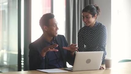 Wall Mural - Indian female mentor helping african american intern explaining computer work