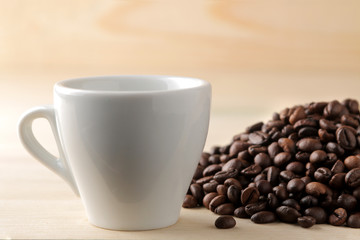 Roasted coffee grains and a cup of coffee on a brown wooden background. Robusta, Arabica.