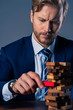 © whyframeshot - business man try to build wood block on wooden table and black background business organization startup concept
