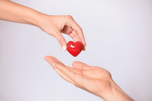 Woman Giving Red Heart To Man On White Background, Closeup. Donation Concept