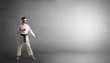 © ra2 studio - Small karate man fighting in an empty grey copy space