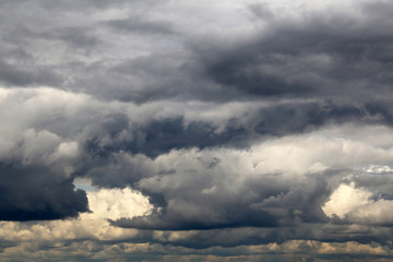 Storm sky covered with dark cumulus clouds before the rain. Dark cloudy sky, overcast day, beautiful dramatic background for stormy weather