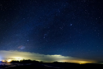 Wall Mural - Starry sky above the clouds. Clouds are illuminated by lanterns.