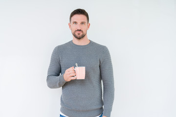 Young man driking cup of coffee over isolated background with a confident expression on smart face thinking serious