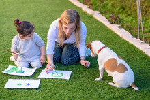 Happy Family With Jack Russell Terrier Dog Drawing And Playing In Summer Garden. Family Love, Summer Vacation, Holiday, Learning Concept.