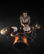 © puhimec - Professional drummer playing on drum set on stage on the black background