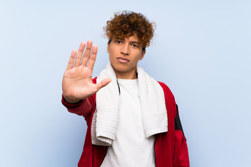 Wall Mural - Young sport african american man making stop gesture with her hand