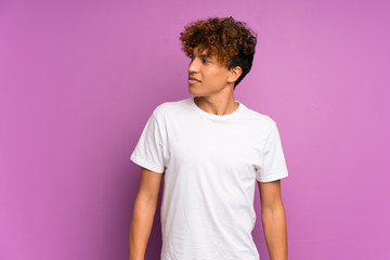 Wall Mural - Young african american man over isolated purple wall making doubts gesture looking side