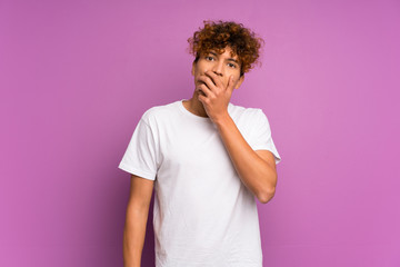 Wall Mural - Young african american man over isolated purple wall surprised and shocked while looking right