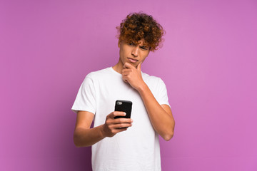 Wall Mural - Young african american man over isolated purple wall thinking and sending a message