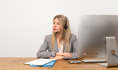 Wall Mural - Young woman working with headset looking side