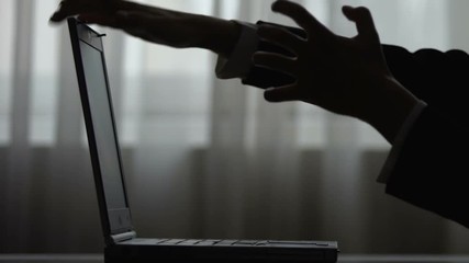 Silhouette of female hands expressing irritation from failed program on laptop