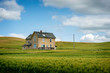 Abandoned Farmhouse in a Wheat Field. A classic farmhouse located in the palouse area of eastern Washington state sits in the middle of a maturing wheat field abandoned long ago as the main residence.