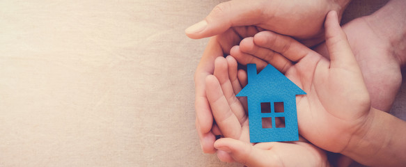 hands holding paper house, family home, homeless shelter, international day of families, foster home care, family day care, social distancing, stay at home, housing mortgage crisis concept