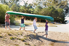 Family Carrying A Canoe For An Outdoor Adventure