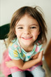 © Maria Manco/Stocksy - photo of little girl in tutu sitting on chair in home
