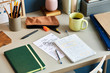 © 365mm/Stocksy - Workplace with notebooks and notes with cup of coffee in dayligh