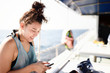 © Silk And Salt Images/Stocksy - Sporty woman using her phone on a boat at sea