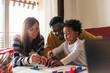 © Santi Nunez/Stocksy - Happy multiethnic family having fun and drawing at home.