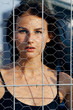 © Amsterdam/Stocksy - young woman behind fence