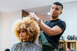 © Santi Nunez/Stocksy - Beautiful afro woman getting haircut by hairdresser in the beauty salon