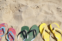 Colorful Flip Flops In Row On Sand In Summer, Copy Space For Text. Beach Accessories.