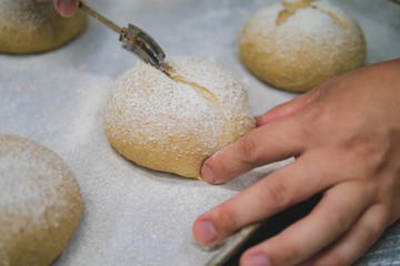 Baking course, using a knife to cut the surface of bread