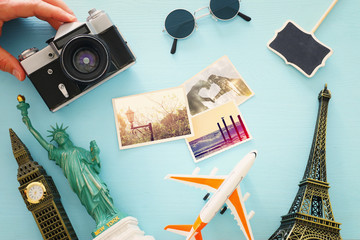 Wall Mural - Top view photo of traveling concept with accessories and world symbols over blue background