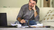 © TheVisualsYouNeed - stressed and desperate man at home living room couch doing domestic accounting with paperwork and calculator feeling overwhelmed and worried suffering financial crisis