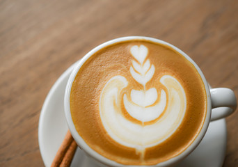 Heart-shaped latte coffee on a wooden table. Top view and Close up shoot.