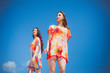 © alipko - Two gorgeous young women wearing swimmwear, against the blue sky