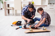 © Elnur - Young father repairing skateboard with his son at home