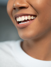 Closeup Of Woman Smiling With Prefect White Teeth Isolated Over Concrete Studio Background. Dental Health And Lip Care Concepts
