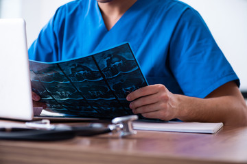 Young male doctor looking at x-ray images