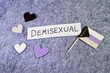 Handwritten Word Demisexual on Gray Background with Demi Flag and Hearts