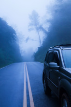 SUV Car On A Mountain Road In The Mist.