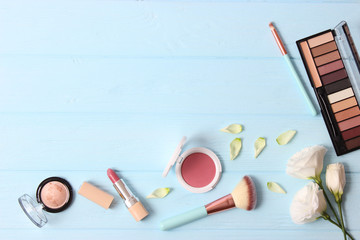 cosmetics and flowers on a colored background top view.