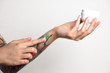 © Artem Markin - Female tattooed hands hold a jar of cream. Fingers apply cream to skin