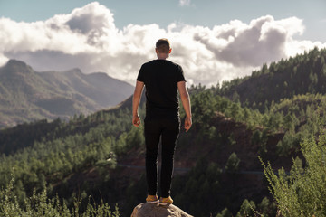 Happy young tall man from behind standing and enjoying life in the mountains of gran canaria, canary islands, spain