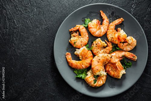 Fotografía Grilled shrimps on plate on dark background