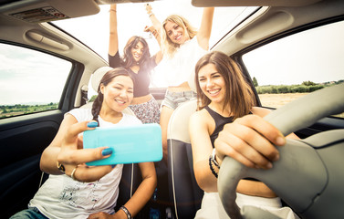 Women having fun driving in a convertible car