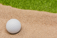 White Golf Ball In Sand Bunker On Golf Court.
