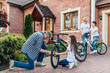 © Тарас Нагирняк - Grandfather near his house with kids repair the bike. Bicycle mechanic in a workshop in the repair process
