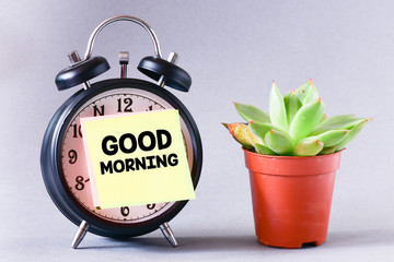 close-up view of retro alarm clock and sticky note with inscription good morning on grey background 