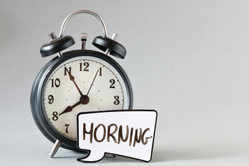 close-up view of retro alarm clock and speech bubble with inscription morning on grey background 
