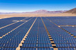 Aerial view of hundreds solar energy modules or panels rows along the dry lands at Atacama Desert, Chile. Huge Photovoltaic PV Plant in the middle of the desert from an aerial drone point of view