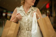 © Mihail - happy adult woman with shopping bags in supermarket, making purchases clothes