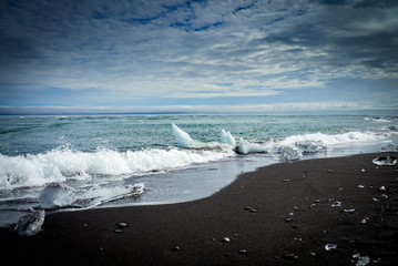 Wall Mural - Iceberg crushing on black beach in Iceland