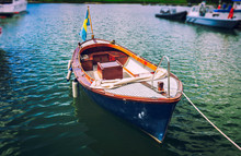 Classic Traditional Wooden Boat On The Water With Swedish Flag
