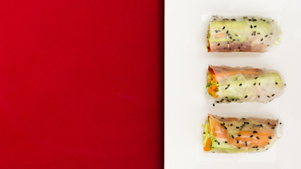 Wall Mural - An elevated view of fresh vegetable and salmon fish spring rolls on plate